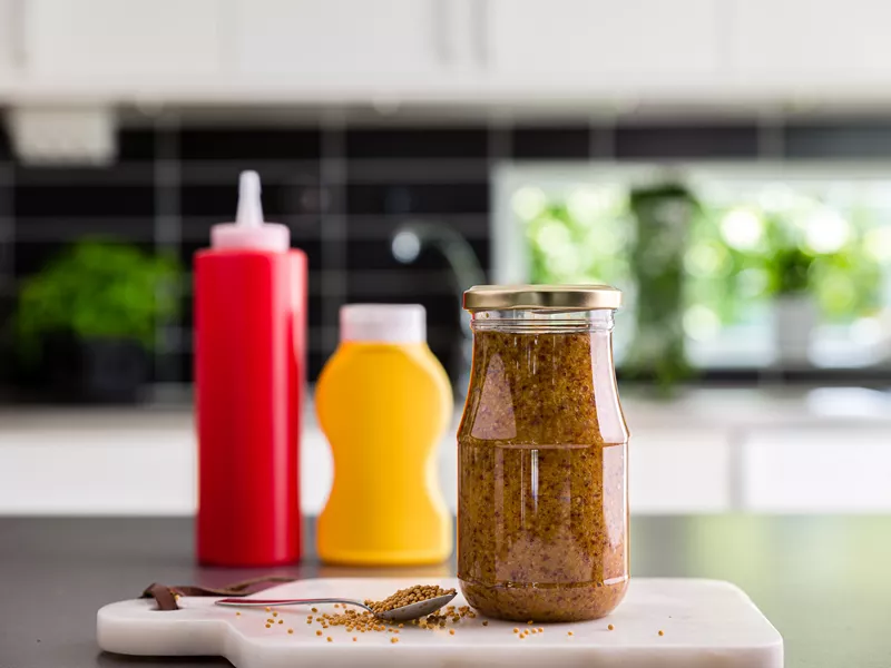 Sennepsglas i plastikemballage perfekt til sennep og saucer